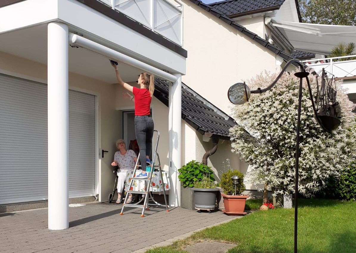 Eine Jugendliche der Taschengeldbörse im Einsatz für eine ältere Dame