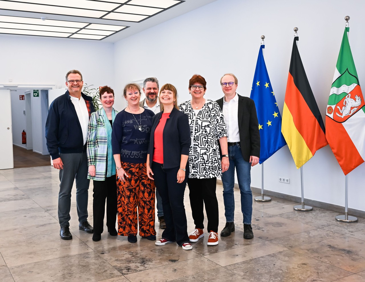 Das Bild zeigt sechs der sieben Sprecherinnen und Sprecher des NBE NRW mit der Staatssekretärin für Sport und Ehrenamt Andrea Milz.